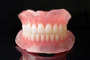 Full set of dentures against dark background