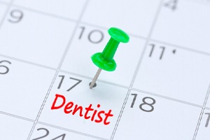 Dental appointment marked on calendar with green thumbtack