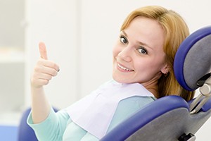 Smiling woman giving thumbs up after dental checkups and teeth cleanings