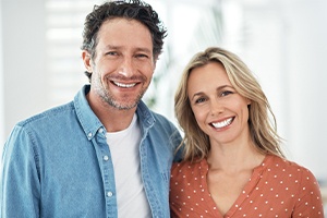 Man and woman smiling after one visit dental restoration