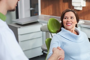 Woman shaking dentist's hand after root canal therapy