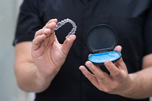 Dental team member holding Invisalign aligners