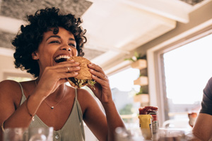 Happy young woman enjoying a burger