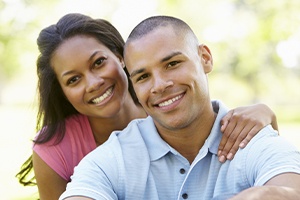 Man and woman smiling after metal free dental restoration