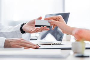 Patient handing over card to pay for dental treatment