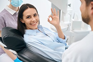 Happy dental patient making OK sign with hand