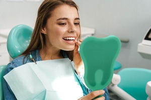 Satisfied patient admiring the results of her dental bonding