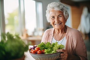 Smiling grandmother holding a big salad