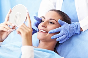 Female patient admiring smile after receiving tooth-colored fillings