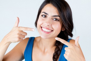 Young woman showing off her dental implant restorations