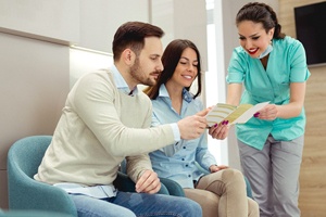 Couple discussing payment options with dental team member