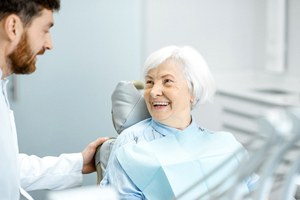 Patient and dentist talking after implant dentures procedure