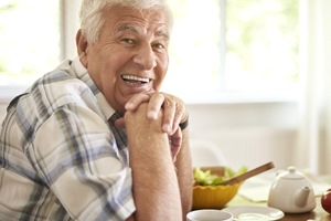 Smiling senior man enjoying the benefits of implant dentures