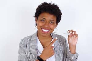 Portrait of happy businesswoman pointing at her Invisalign aligner