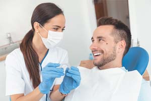 Happy dentist and patient discussing the cost of Invisalign