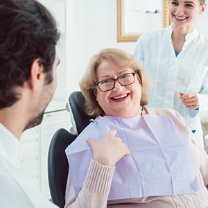 Woman in dental chair smiling after periodontal therapy