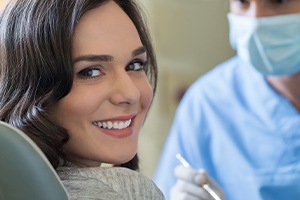 Woman in dental chair talking to dentist