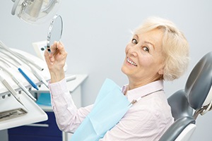Woman looking at smile after periodontal therapy
