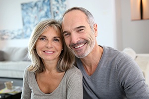 Man and woman sharing smiles after full mouth reconstructions