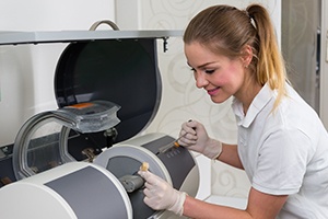 Woman using in office CEREC milling unit