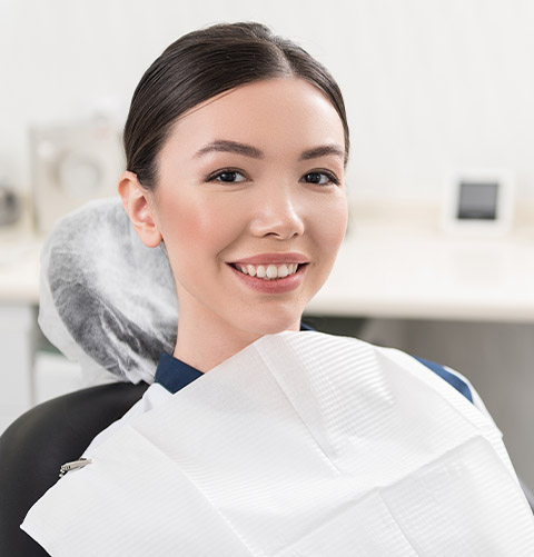 Smiling woman in dental chair for preventive dentistry visit