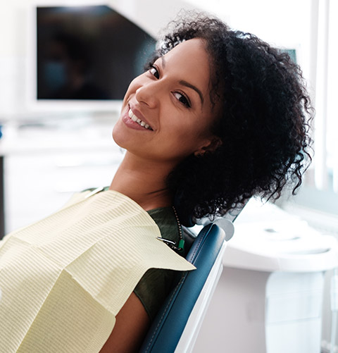 Woman in dental chair smiling during dental checkup visit