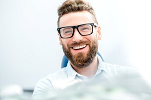 Man in glasses enjoying benefits of smile makeover