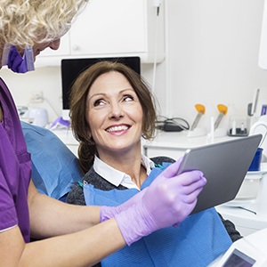 Woman in dental chair smiling at dentist