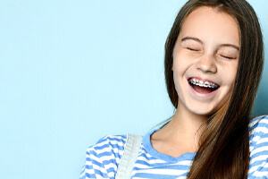Laughing teen girl in striped shirt with traditional braces