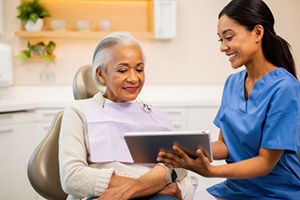 Patient and dental team member looking at tablet together