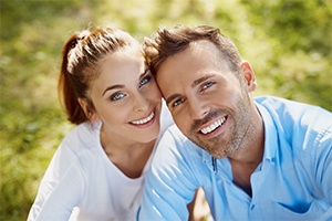 Man and woman with beautiful smiles after porcelain veneer treatment