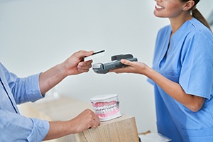 Patient handing over card to pay for dental treatment