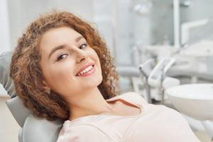 Happy woman at appointment to maximize dental insurance benefits