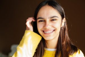 Teen girl in yellow sweater with traditional braces in East Hartford