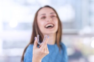 Smiling woman trying to fix TMJ with Invisalign