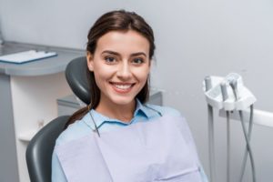 Dental patient sitting in treatment chair, smiling