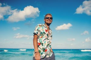 Smiling man walking on the beach