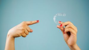 Woman’s hands holding Invisalign aligner