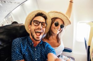 Young couple taking selfie on airplane