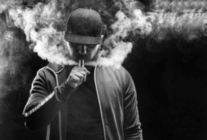 Black and white photo of man using e-cigarette