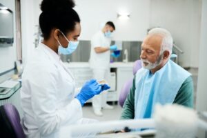 Senior man talking to dentist about dentures 
