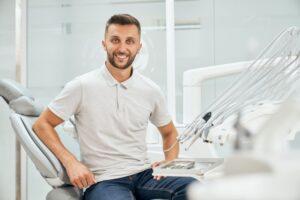 Young adult man sitting up in dental treatment chair 