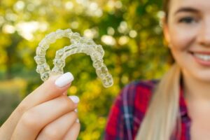 Teen girl holding two Invisalign aligners