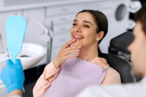 Cosmetic dentistry patient looking at her smile in mirror